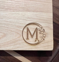 Detail image of the monogrammed board with an M engraved into the bottom right