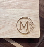 Detail image of the monogrammed board with an M engraved into the bottom right