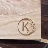 Detail image of the monogrammed board with an K engraved into the bottom right