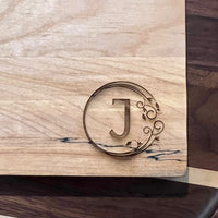 Detail image of the monogrammed board with an J engraved into the bottom right