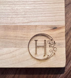 Detail image of the monogrammed board with an H engraved into the bottom right