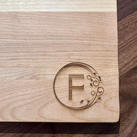 Detail image of the monogrammed board with an F engraved into the bottom right