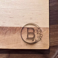 Detail image of the monogrammed board with an B engraved into the bottom right
